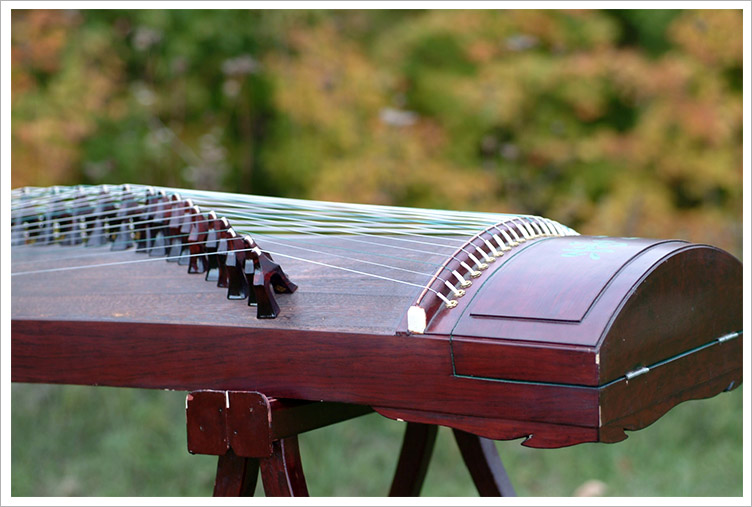 Close-up of an ornately decorated traditional Chinese Guzheng with 21 strings